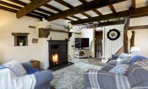 uma sala de estar com dois sofás e uma lareira em Finest Retreats - Ellen's Cottage em Bury