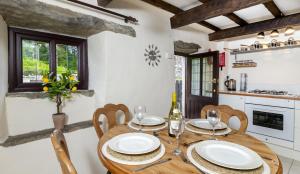 a dining room with a table and chairs and a kitchen at Finest Retreats - Ellen's Cottage in Bury