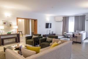 un ampio soggiorno con divano e sedie di Pier Harbour Residences and Spa a Lagos