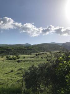 a green field with mountains in the background at Kasaj Villa in Gjirokastër