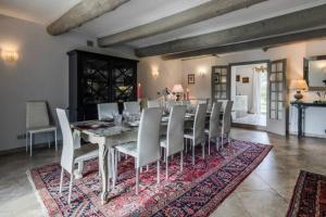 a dining room with a table and chairs on a rug at La Commanderie - 18 pers. Piscine privée chauffée in Saint-Gilles