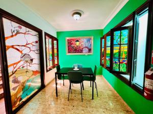 a dining room with green walls and a black table and chairs at Suite Colonial by Cristi in Santo Domingo