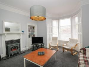 a living room with a table and a fireplace at Willowbank in Ayr