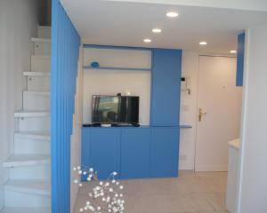 ein Wohnzimmer mit blauen Wänden und einem TV in der Unterkunft Attico Victoria Palace suggestivo e spettacolare in Menton