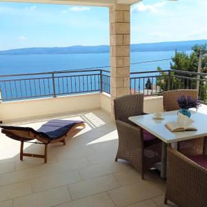 a balcony with a table and chairs and the ocean at Apartments Mirko in Mimice