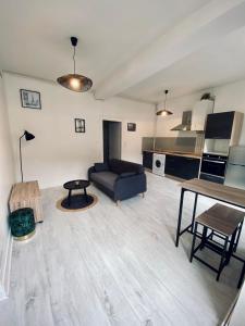 ein Wohnzimmer mit einem Sofa und einem Tisch in der Unterkunft Le Moderne in Issoudun
