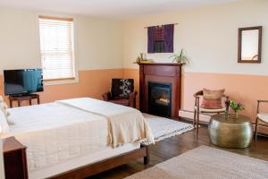 1 dormitorio con 1 cama y chimenea en The Vesper Woodstock en Woodstock