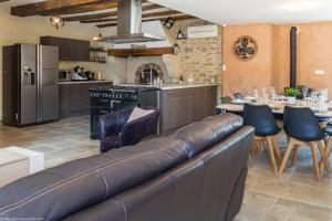 a living room with a leather couch in a kitchen at Les Gîtes du Griffon l'Erable in Aubigny-lès-Sombernon +27 photos