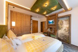 a bedroom with two beds and a green ceiling at Hotel Sporthof Austria in Ramsau am Dachstein