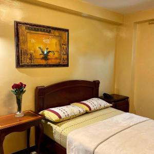 1 dormitorio con 1 cama y una foto en la pared en Hostal Montesa, en Guayaquil