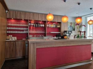 un bar in un ristorante con luci arancioni di Rathaushotels Oberwiesenthal All Inclusive a Oberwiesenthal