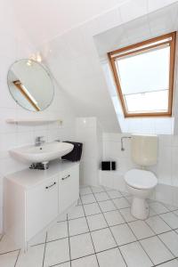 カロリーネンジールにあるFerienwohnung Oberdeckの洗面台とトイレを備えた白いバスルーム +8枚の写真