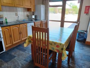 a kitchen with a table and chairs and a kitchen with a sink at Dunroaming Cottage in Pendine