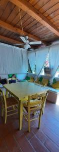 un tavolo giallo e un soffitto con ventilatore a soffitto di Appartamento a Punta Asfodeli a Porto Rotondo