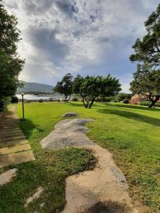 un sentiero in pietra in un prato alberato di Appartamento a Punta Asfodeli a Porto Rotondo