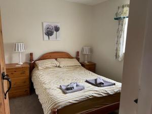 a bedroom with a bed with two slippers on it at Beck House Cottages in Pickering