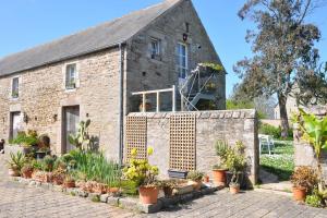 ein Backsteingebäude mit Pflanzen davor in der Unterkunft Les Hortensias in Gatteville-le-Phare
