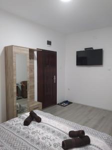 1 dormitorio con 1 cama con 2 zapatillas marrones en Lotus house en Zrenjanin