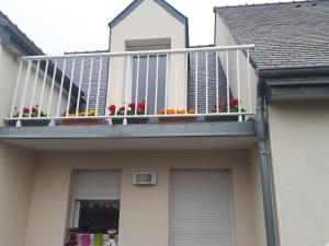 een balkon op een huis met bloemen erop bij macareux in Binic