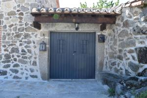 une porte dans un bâtiment en pierre avec un mur en pierre dans l'établissement Casa Rural El Balcón de Piedrahíta, à Navahermosa de Corneja