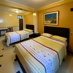 a hotel room with two beds in it at Hostal Montesa in Guayaquil