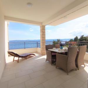 a patio with a table and chairs on a balcony at Apartments Mirko in Mimice