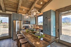 eine Küche mit einem großen Holztisch und einigen Fenstern in der Unterkunft Stunning Kalispell Cottage on 30-Acre Farm! in Kalispell