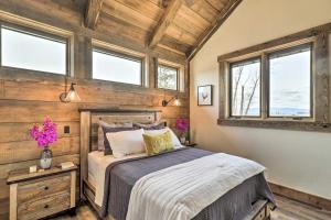 ein Schlafzimmer mit einem Bett in einem Zimmer mit Fenstern in der Unterkunft Stunning Kalispell Cottage on 30-Acre Farm! in Kalispell