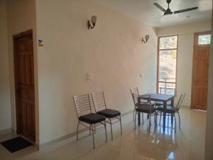 a dining room with a table and chairs and a window at Hotel Cozy Haven in Mandi