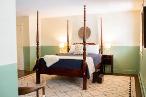 a bedroom with a four poster bed and green walls at The Vesper Woodstock in Woodstock