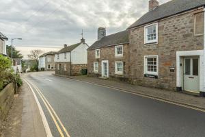 an empty street in a village with stone houses at Porthgwidden Cottage in Uny Lelant