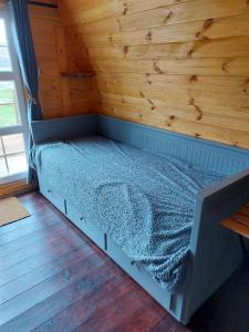 a bed in a room with a wooden wall at Pod 4 in Skail