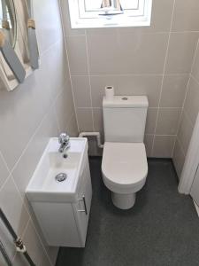 Łazienka z białą toaletą i umywalką w obiekcie Beautiful 3 bed house in Hunstanton - near Searles with sea views w mieście Hunstanton