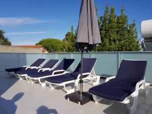 カルダス・ダ・ライーニャにあるMoinho Branco (molen)の屋根の上に並ぶラウンジチェアと傘