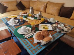 un tavolo per la colazione con cibo e bevande su un divano di Riad Bonheur a Marrakech