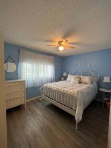 a bedroom with a bed and a ceiling fan at Main Floor Bright & Spacious Apartment in Lethbridge