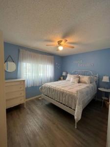 1 dormitorio con 1 cama y ventilador de techo en Main Floor Bright & Spacious Apartment, en Lethbridge