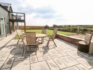 a patio with chairs and a table on a patio at Glowty Brynbedw in Clynderwen