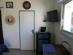 ein Zimmer mit einer weißen Tür, einem Tisch und einer Uhr in der Unterkunft Challans in Challans
