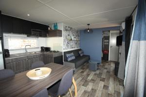 a kitchen and living room with a table and a kitchen and a dining room at Mobil Home Vue sur Mer - Racine 03 in Saint-Raphaël