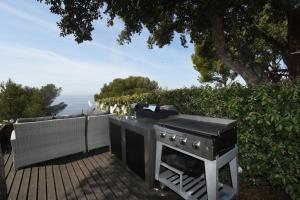 a grill on a deck with the ocean in the background at Mobil Home Vue sur Mer - Racine 03 in Saint-Raphaël