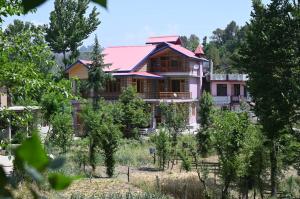 Kavya Home Stay في Chachyot: منزل وسط حديقة فيها اشجار