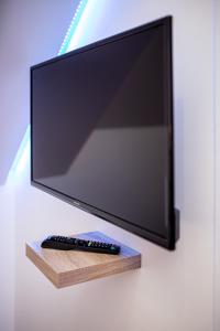 A television and/or entertainment centre at Suite SPAtio - Jacuzzi Privé - 20min Disneyland PARIS