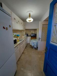 a kitchen with white cabinets and a blue door at Παραδοσιακό σπίτι με πανοραμική θέα in Andros