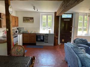 a living room with a kitchen with a couch and a table at Moulin des Forges Gites, Camping et Glamping in Moutier-Malcard