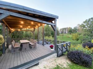 a wooden pergola with a picnic table on a deck at Ligatne Homestay in Līgatne