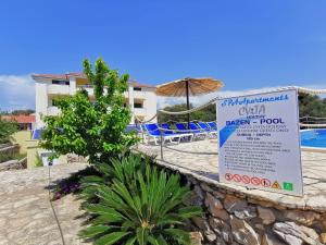 un cartel en una pared junto a una piscina en Apartments CVITA HOLIDAY - Villa NATALI, en Rogoznica