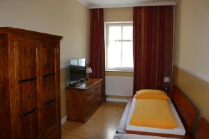 ein Schlafzimmer mit einem Bett, einer Kommode und einem Fenster in der Unterkunft Gutshof Sagritz in Golßen
