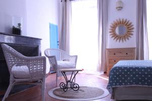 ein Schlafzimmer mit 2 Stühlen, einem Bett und einem Spiegel in der Unterkunft Studio la maison bleue in Cotignac