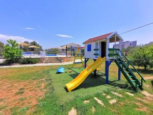 a playground with a slide and a house at Apartments CVITA HOLIDAY - Villa NATALI in Rogoznica